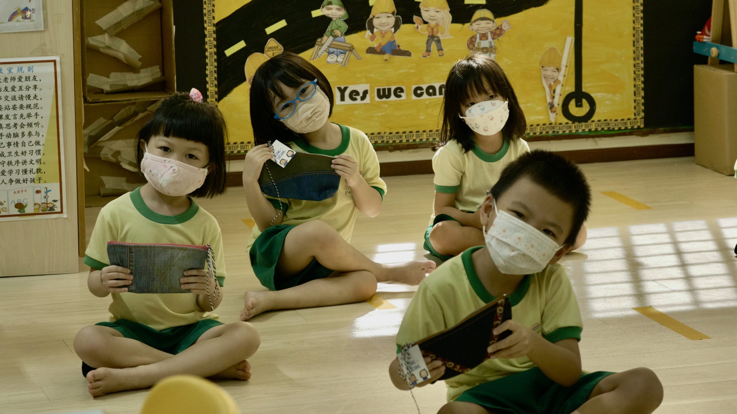 Preschoolers under Presbyterian Preschool Services receiving the pencil cases that were sewed by the elderly.